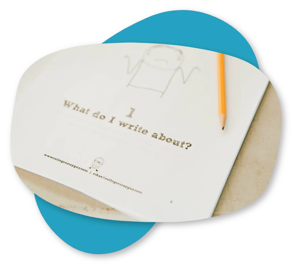 A paper titled "What do I write about?" with a simple drawing of a person and a pencil resting on it, placed on a beige surface.
