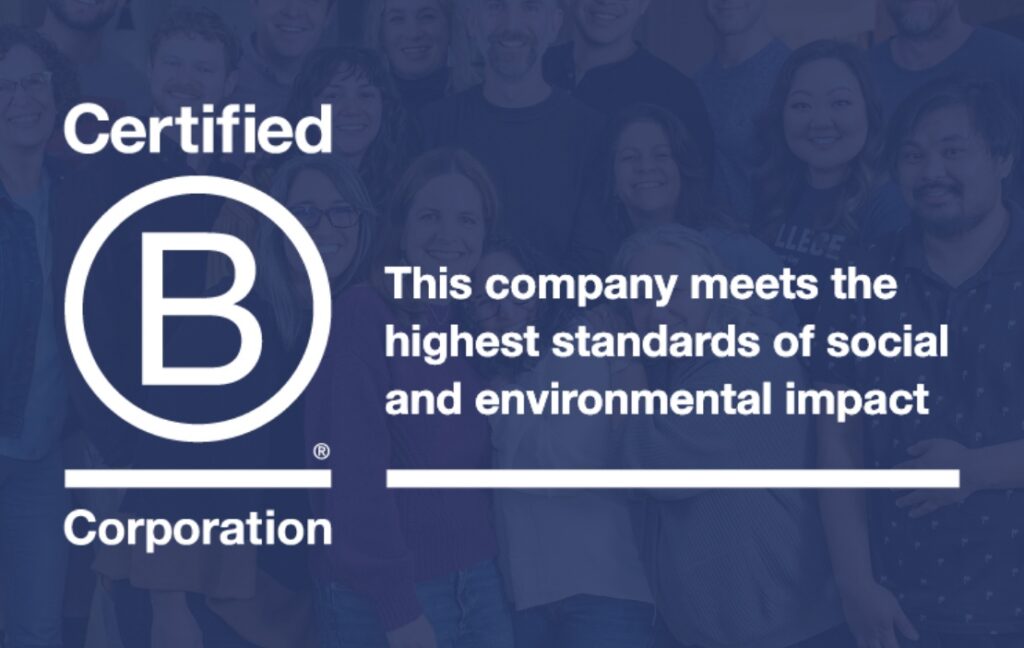 A group of people stands behind a large white “Certified B Corporation” logo with text stating the company meets high social and environmental standards.